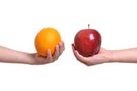 hands holding apple and orange representing comparing colleges with high percentage of pell grant students