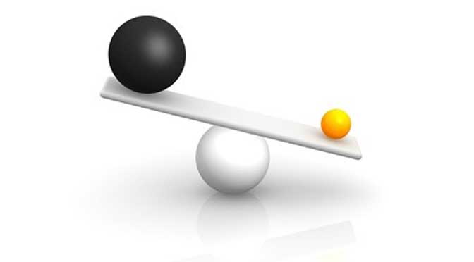 small ball outweighing a large ball on a balance representing benefit of small colleges