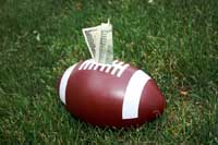 college football with money representing sports scholarships