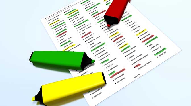 Two highlighters (green and yellow) lying on a printed college search cheat sheet with various color-coded data points and a red pen atop the paper.