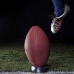 foot kicking a football representing how to start college athletic recruiting process