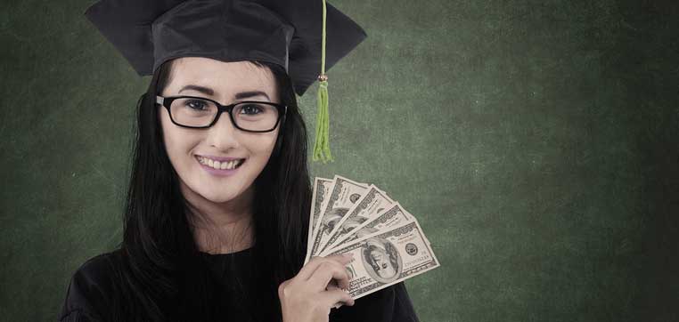 A person wearing graduation robes and a cap holds five $100 bills against a green textured background, celebrating the achievement made possible by affordable public universities.
