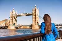 student looking at London bridge representing paying for college in Europe