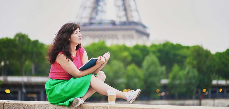 Student studying in front of Eiffel tower representing requirements for applying to colleges abroad