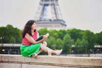 student sitting in front of Eiffel tower rerpresenting requirements for applying to college abroad