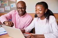 Father helping daughter with test prep decisions at laptop