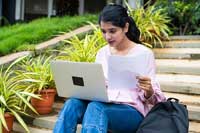 Female student using New York Times Build Your Own College Rankings tool on a laptop